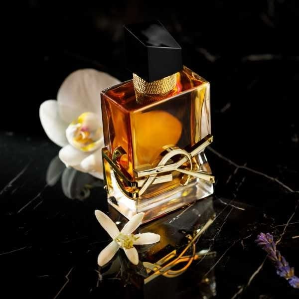 Refect Beauty Yves Saint Laurent Libre Intense perfume bottle with gold accents and white orchid on black marble