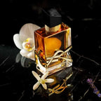 Refect Beauty Yves Saint Laurent Libre Intense perfume bottle with gold accents and white orchid on black marble