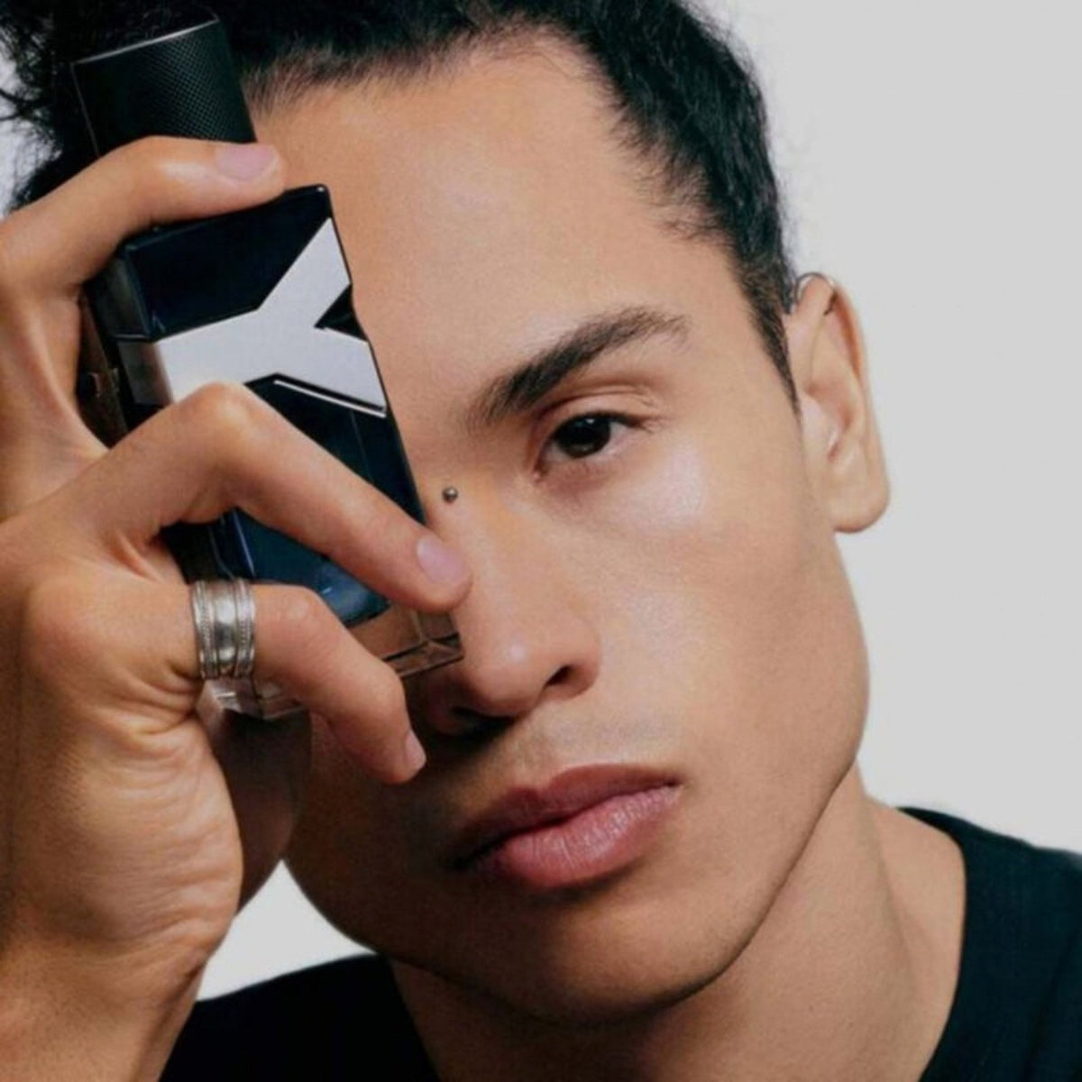 Refect Beauty model holding a bottle of Yves Saint Laurent Y Eau de Parfum against his face